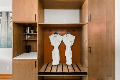a wardrobe with two white suits hanging in it at Sproat Lake Landing Resort in Port Alberni