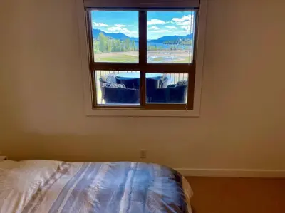a bedroom with a large window with a view at Lake View From Every Window! in Invermere