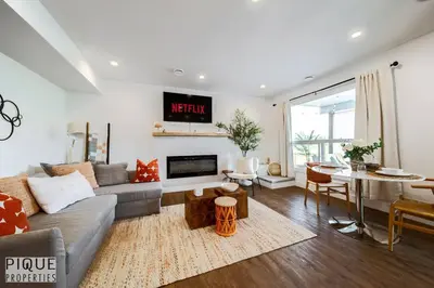 a living room with a couch and a table at Brand New Pond Paradise - Firetable - King Bed - AC - BBQ in Edmonton