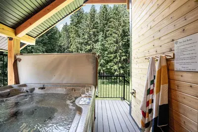 a jacuzzi tub in a wooden house with a porch at The Cedar Suite - Secluded Mountain Retreat with Forest Views and Hot Tub in Revelstoke