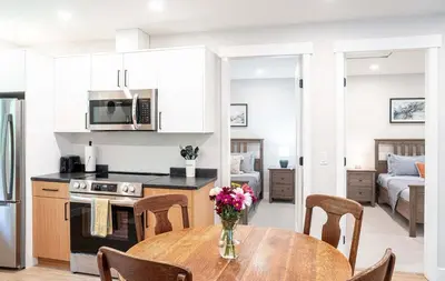 a kitchen and dining room with a table and chairs at The Cedar Suite - Secluded Mountain Retreat with Forest Views and Hot Tub in Revelstoke