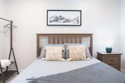 a bedroom with a bed with pillows and a picture on the wall at The Cedar Suite - Secluded Mountain Retreat with Forest Views and Hot Tub in Revelstoke