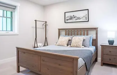 a bedroom with a wooden bed with pillows at The Cedar Suite - Secluded Mountain Retreat with Forest Views and Hot Tub in Revelstoke