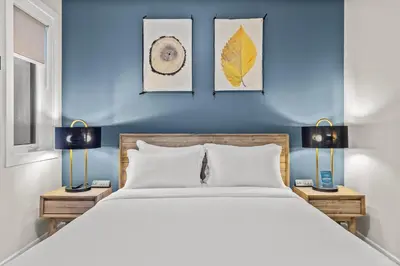a bedroom with a blue wall with a bed and two lamps at Sisters Summit Villa by WeekAway Vacations in Canmore