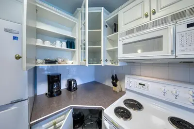 a kitchen with white cabinets and a stove top oven at Mountain View Villas with Fairmont Creek Vacation Rentals in Fairmont Hot Springs