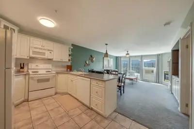 a kitchen with white cabinets and a dining room at Mountain View Villas with Fairmont Creek Vacation Rentals in Fairmont Hot Springs