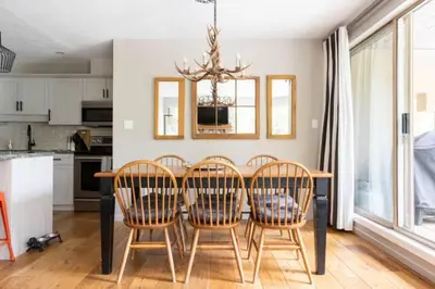 a dining room table with chairs and a kitchen at Whistler Gleneagle 27 in Whistler