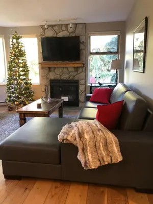 a living room with a couch and a christmas tree at Whistler Gleneagle 27 in Whistler