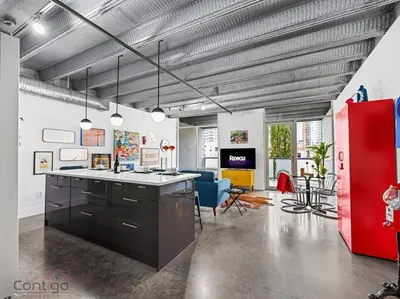 a room with a kitchen and a living room with a red refrigerator at Urban Pop Loft, Near ICE District, UG Parking in Edmonton