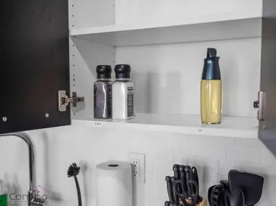 three bottles on a shelf above a kitchen counter at Urban Pop Loft, Near ICE District, UG Parking in Edmonton