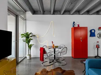 a living room with a table and a red cabinet at Urban Pop Loft, Near ICE District, UG Parking in Edmonton