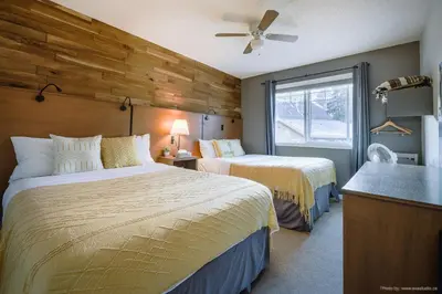 a hotel room with two beds and a window at Entire Lovely Townhouse Mountain View! in Canmore