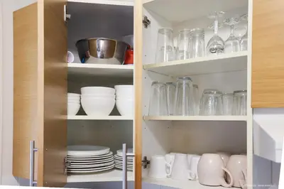 a cupboard filled with plates and glasses and dishes at Entire Lovely Townhouse Mountain View! in Canmore