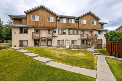 a large house with a lawn in front of it at Entire Lovely Townhouse Mountain View! in Canmore