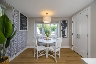 a dining room with a white table and chairs at Boho Bliss - Just steps away from the Hospital in Prince George