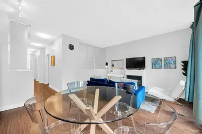 a living room with a glass table and blue chairs at Lovely 2-Bedrooms Downtown suite Free Parking in Vancouver