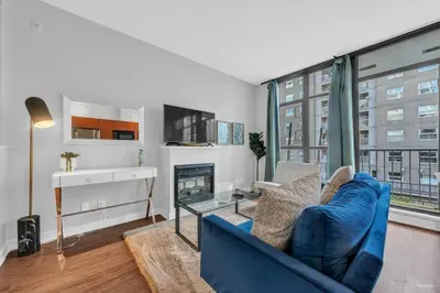 a living room with a blue couch and a fireplace at Lovely 2-Bedrooms Downtown suite Free Parking in Vancouver