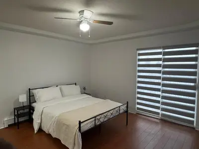 a bedroom with a bed and a ceiling fan at Spacious Getaway in Surrey in Surrey