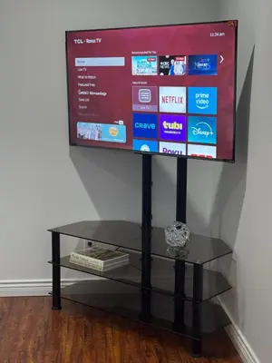 a flat screen tv sitting on a glass table at Spacious Getaway in Surrey in Surrey