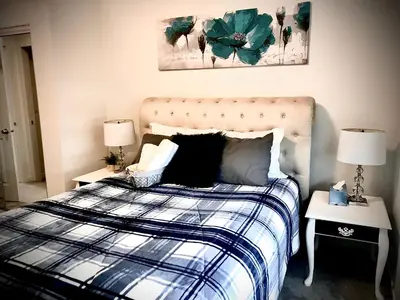 a bedroom with a bed with a blue and white plaid at Humble Living in Edmonton
