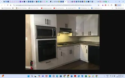 a kitchen with white cabinets and black appliances at Room # 3 Sleep 4 Arrangement in Edmonton