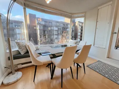 a dining room with a table and chairs and a large window at Beautiful 2 Beds Dwtn apt Free Parking King Bed in Vancouver