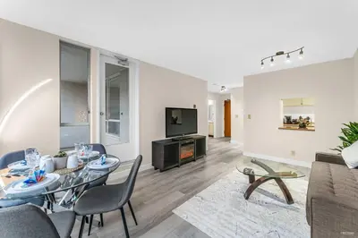 a living room with a dining table and a tv at Beautiful City Two Beds Suite with Free Parking in Vancouver