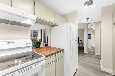 a kitchen with white appliances and a white refrigerator at Beautiful City Two Beds Suite with Free Parking in Vancouver