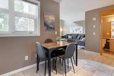 a dining room and living room with a table and chairs at Cozy Condo with Epic Mountain Views, Parking, Air Con in Canmore