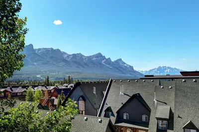 a group of houses with mountains in the background at Cozy Condo with Epic Mountain Views, Parking, Air Con in Canmore