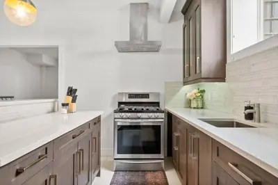 a kitchen with a stove and a sink at Bright & Cozy 2-Bedroom Basement Suite in Chestermere