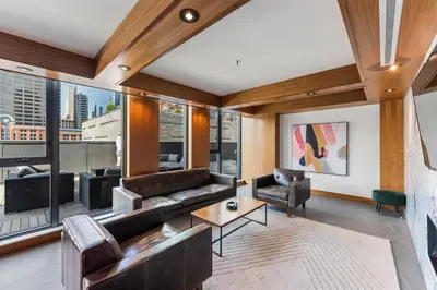 a living room with a couch and a table at Poolside Bliss - 22 FL w Tower Views! FREE Banff Pass, Gym, Parking, Summer Outdoor Pool! in Calgary