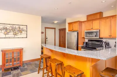 a kitchen with a counter and some wooden cabinets at Stonegate Resort Unit A206 in Kelowna