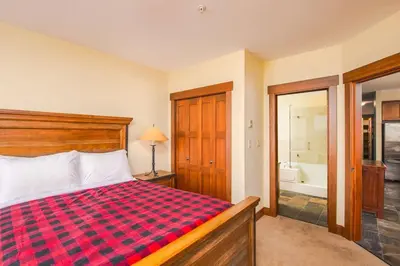 a bedroom with a bed and a bathroom with a tub at Stonegate Resort Unit A206 in Kelowna