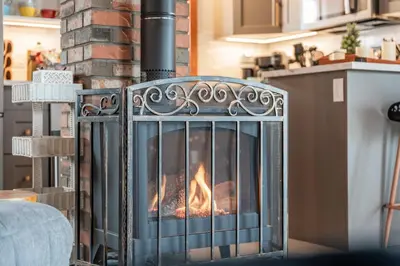 a fireplace with a fire inside of it at The View Point Lodge Cozy Log House with Hot Tub in Vernon