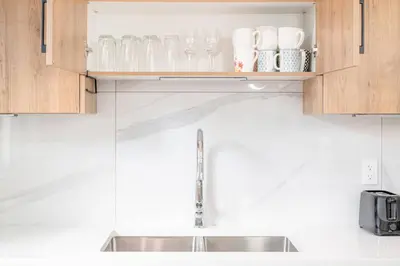 a kitchen with a sink and some cups and glasses at Luxury Family Home - Sleeps 10 - King Bed in Nisku