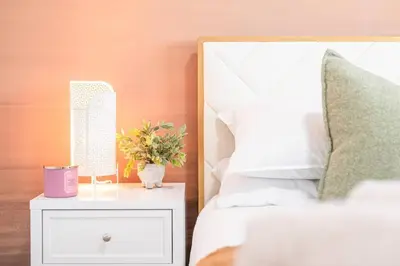 a bedroom with a bed and a nightstand with a mirror at Luxury Family Home - Sleeps 10 - King Bed in Nisku