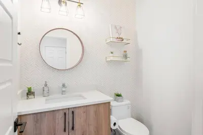 a bathroom with a sink and a mirror and a toilet at Luxury Family Home - Sleeps 10 - King Bed in Nisku