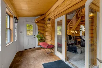 a home office with a staircase and a red chair at Authentic lofted log cabin with hot tub in Kelowna