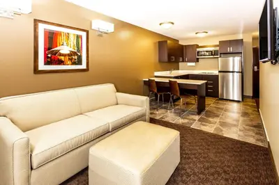 a living room with a couch and a kitchen at Microtel Inn & Suites by Wyndham Whitecourt in Whitecourt