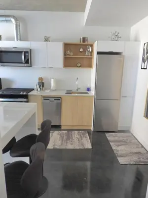 a small kitchen with a sink and a refrigerator at Modern Cozy Nest in Calgary
