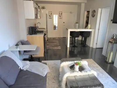 a living room with a couch and a kitchen at Modern Cozy Nest in Calgary