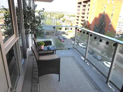 a balcony with a table and chairs on a balcony at Modern Cozy Nest in Calgary
