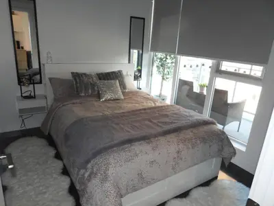 a bedroom with a large bed and a large window at Modern Cozy Nest in Calgary