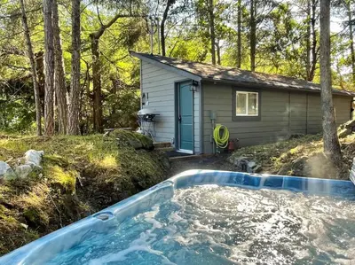 a hot tub in front of a tiny house at Cozy Cabana with Large Private Outdoor Hot Tub in Nanoose Bay