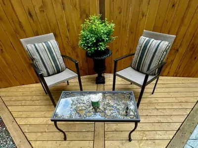 two chairs and a coffee table on a deck at Cozy Cabana with Large Private Outdoor Hot Tub in Nanoose Bay