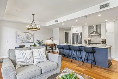 a living room with a couch and a kitchen at Elevated Mountain Living 2BD Spring Creek Unit in Canmore