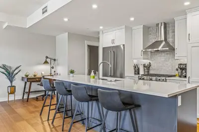 a kitchen with a large island with bar stools at Elevated Mountain Living 2BD Spring Creek Unit in Canmore