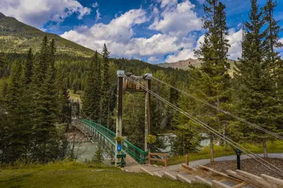 a suspension bridge over a river in the mountains at Horsethief Lodge by StayIn in Panorama