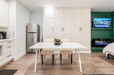 a kitchen with a white table and two chairs at Vancouver Central Green Studio in Vancouver